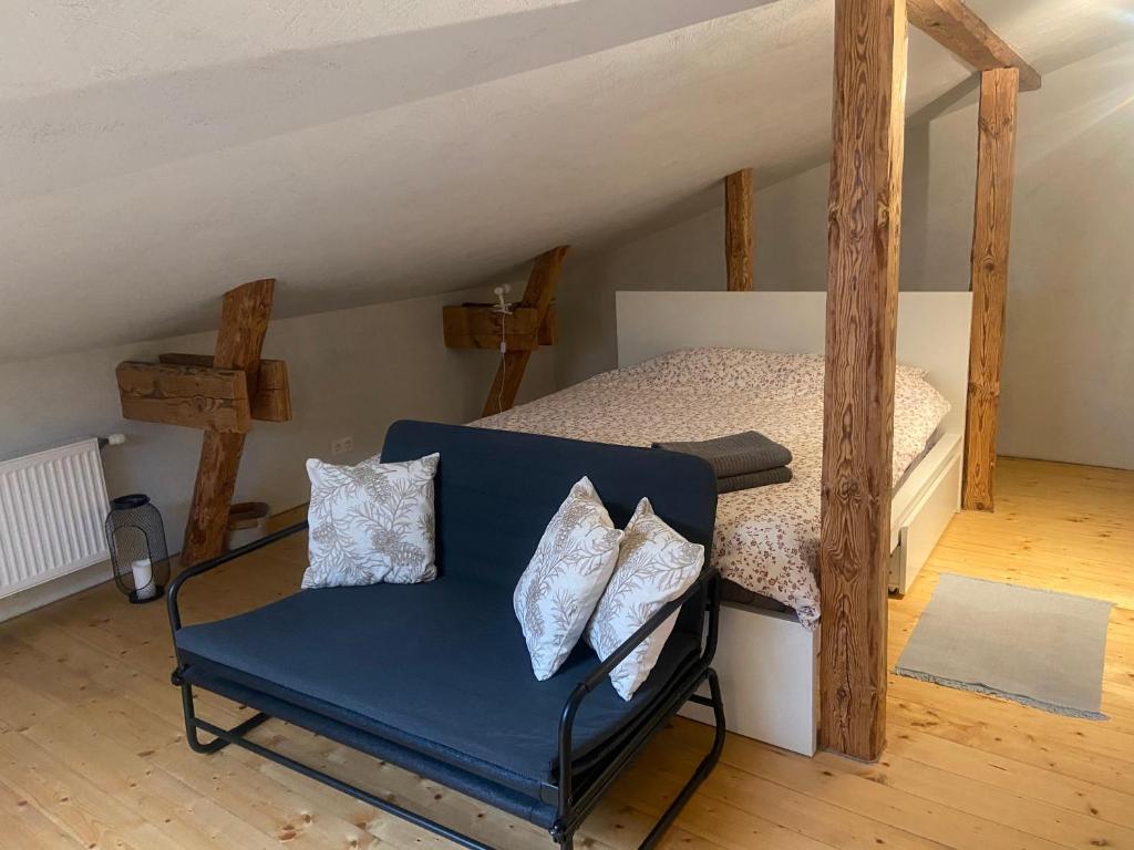 a blue chair in a room with a bed at Cesis city apartment in Cēsis
