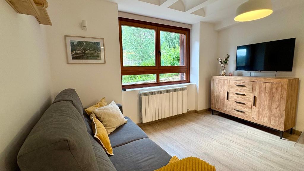 a living room with a couch and a flat screen tv at BPirineos-Mulleres in Benasque