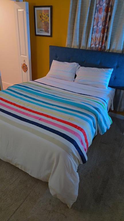 a bed with a colorful striped blanket on it at North in Camby