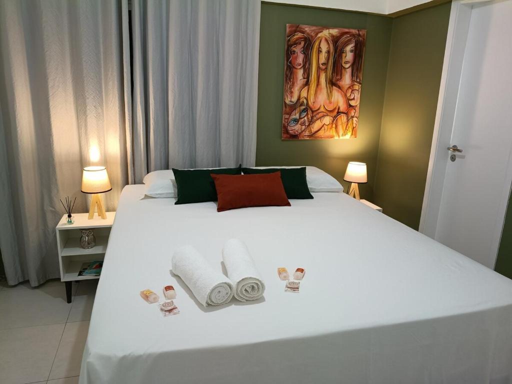 a bedroom with a large white bed with towels on it at Piscina aquecida e varanda, dois quartos com ar condicionado in Aracaju