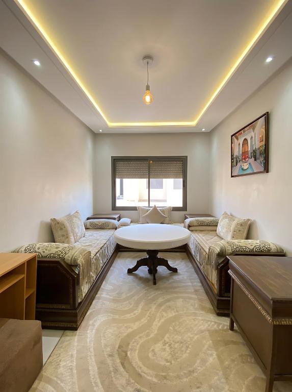 a living room with two couches and a table at Spinoza House Agadir City Apartment in Agadir