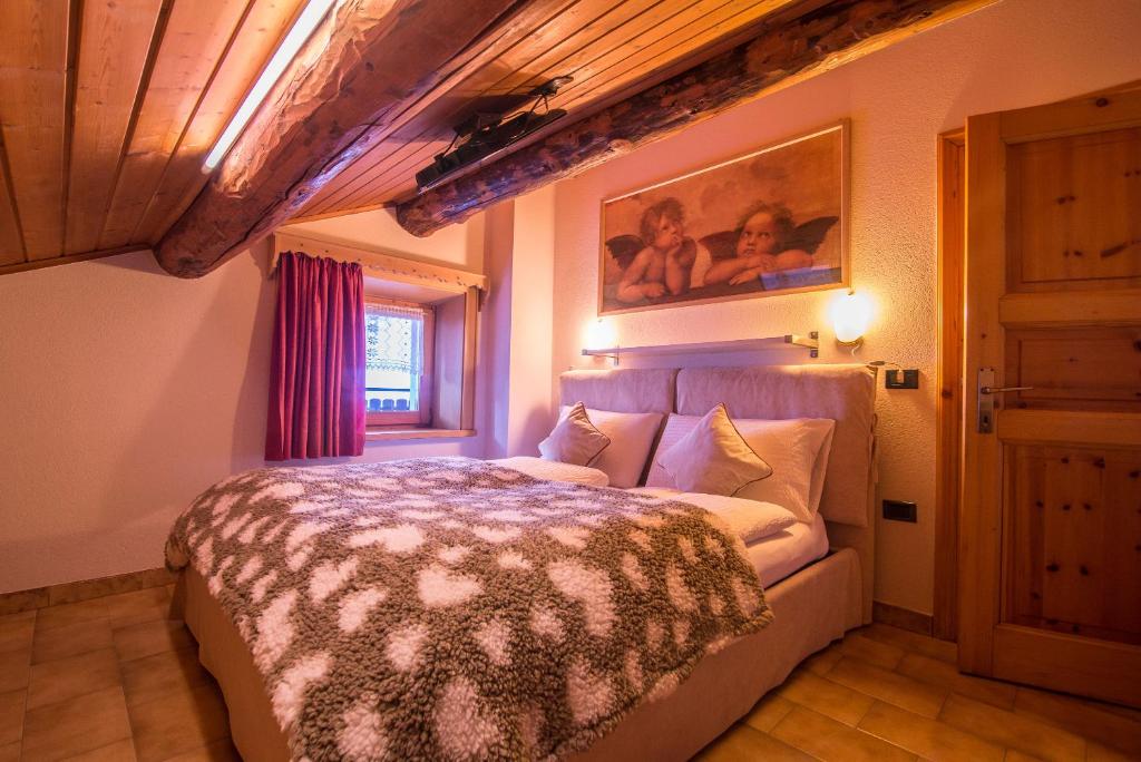 ein Schlafzimmer mit einem Bett und einem Wandgemälde in der Unterkunft Mansardalpina in Livigno