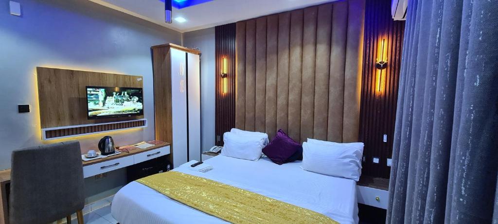a hotel room with a bed and a television at Kiarra Suites Owerri in Owerri