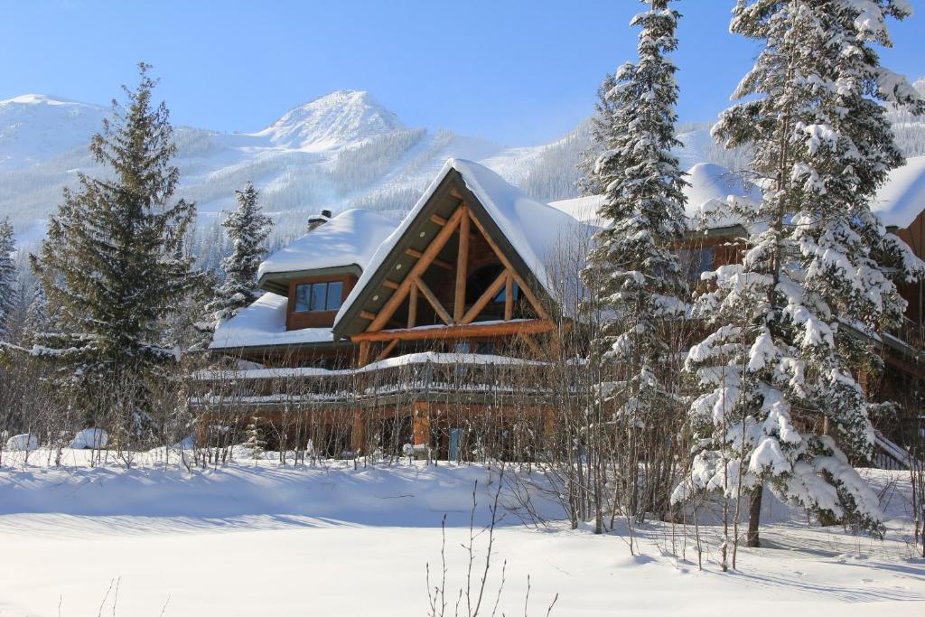 uma cabana de madeira na neve com árvores cobertas de neve em Vagabond Lodge at Kicking Horse em Golden