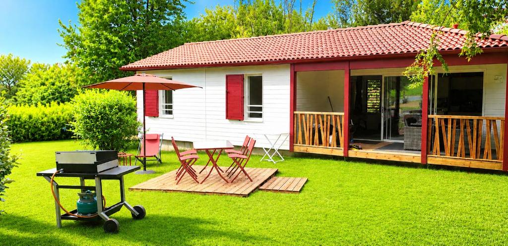 a small house with a grill and a table and chairs at Chalet HABIA TXIKIA 4 pers, neuf, sur Hasparren, calme, avec piscine et climatisation, Pays Basque in Hasparren