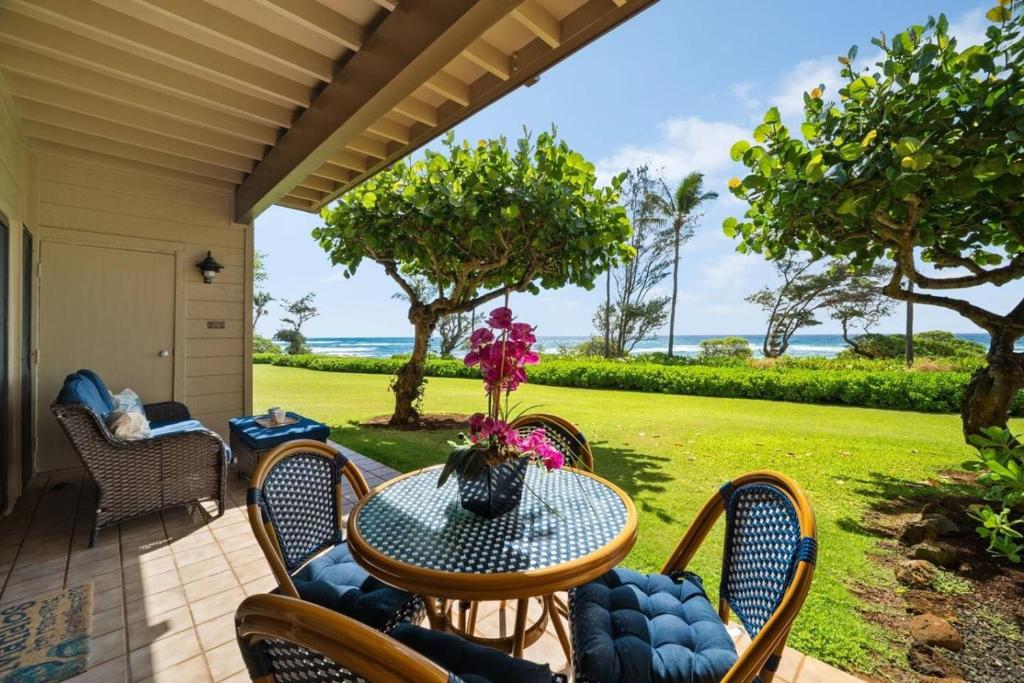a patio with a table and chairs and the ocean at Makai Dream (Oceanfront) in Lihue