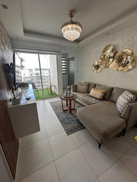 a living room with a couch and a table at The Liras Oasis in Santiago de los Caballeros