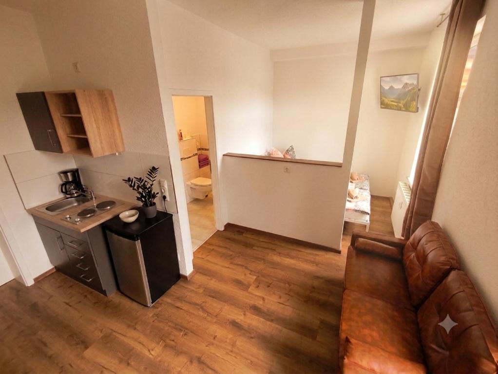 a living room with a couch and a kitchen at Modernes Apartment mit Küche in Groitzsch in Groitzsch