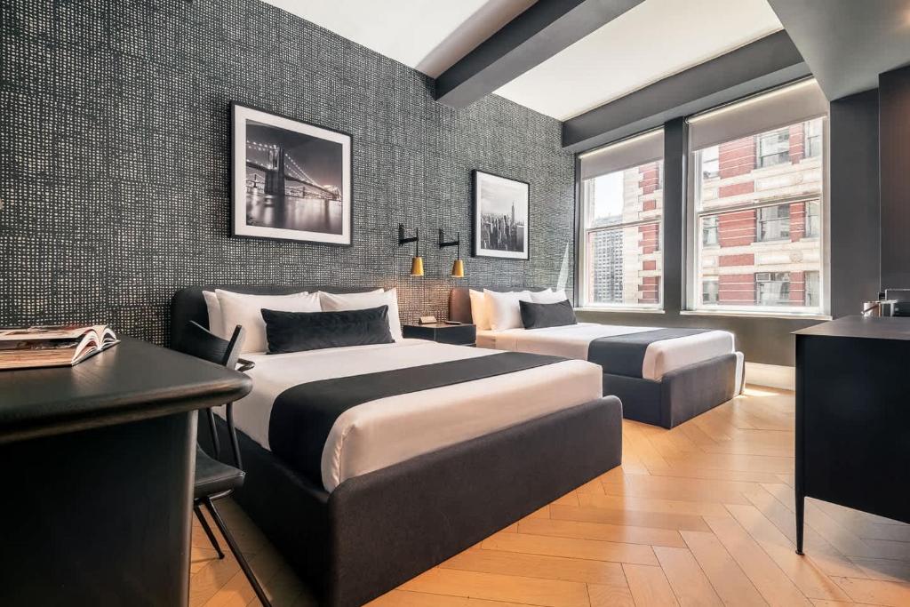 a hotel room with two beds and a desk at Madison Square Hotel Near NoMad in New York