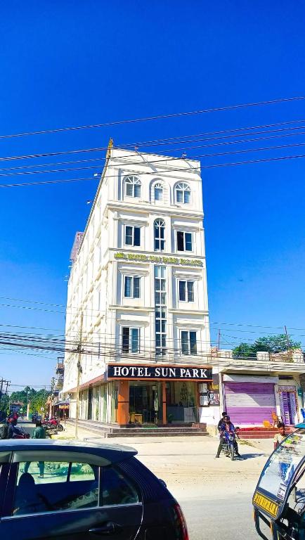 a building on a street with cars parked in front of it at HOTEL SUN PARK Palace in Birātnagar