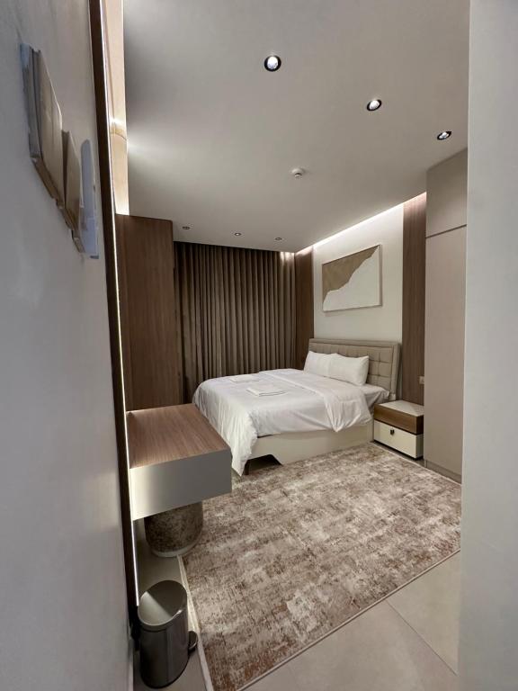 a bedroom with a white bed and a rug at The Pearl Inn in Nizwa