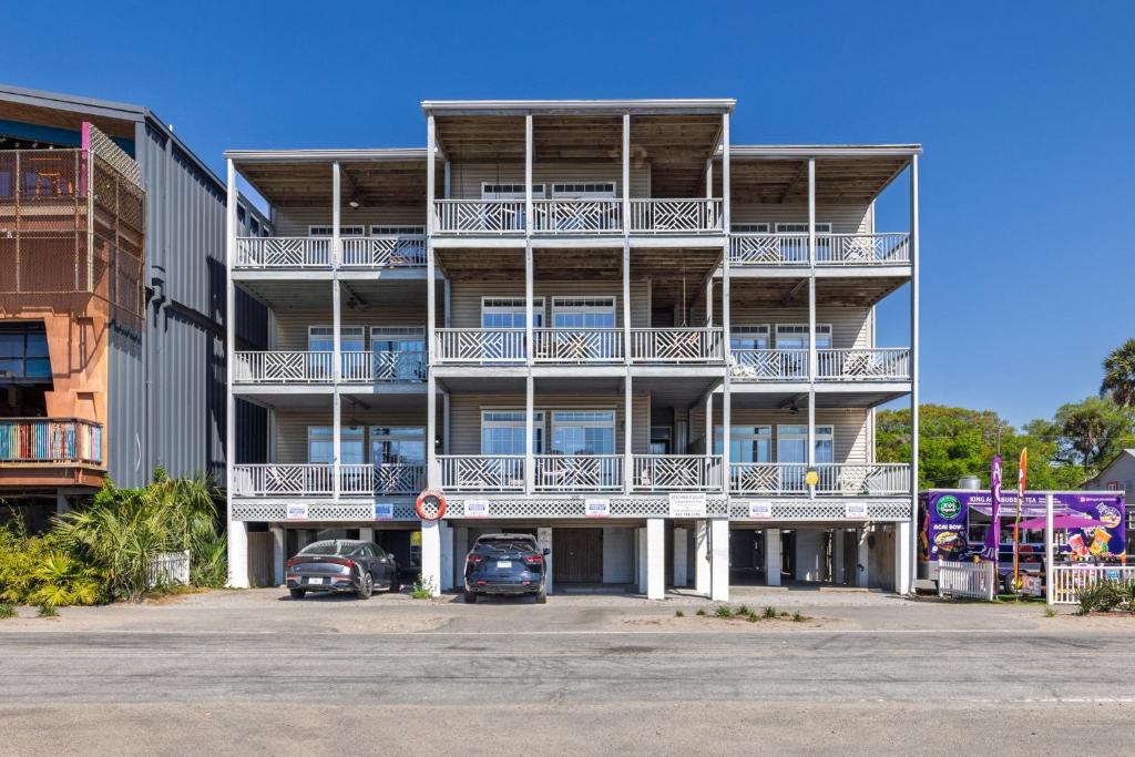 an apartment building with cars parked in a parking lot at Beachwalk Villas 22 in Folly Beach