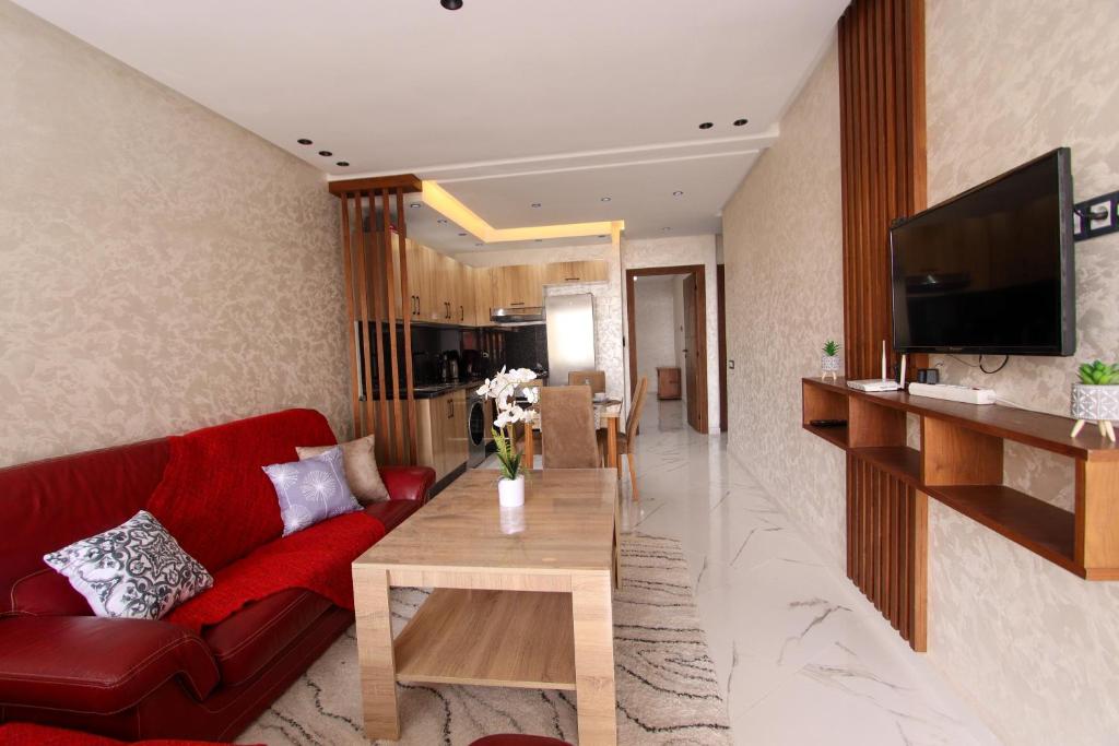 a living room with a red couch and a table at Marina plage in Kenitra