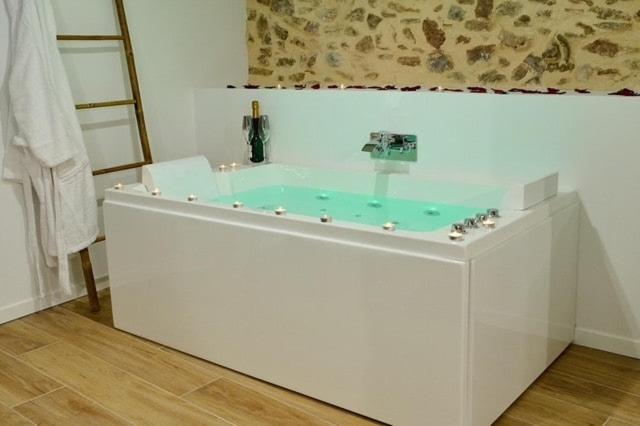 a white bath tub with a blue water in a room at House-Evasion in Tuchan