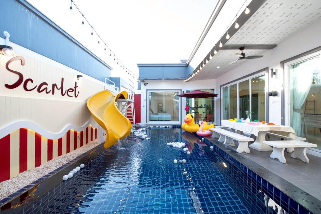 a swimming pool with a slide in a house at Scarlet Poolvilla Pattaya in Na Jomtien