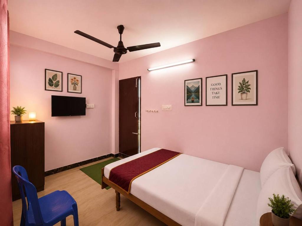 a bedroom with a white bed and a blue chair at Hotel Bypass in Madurai