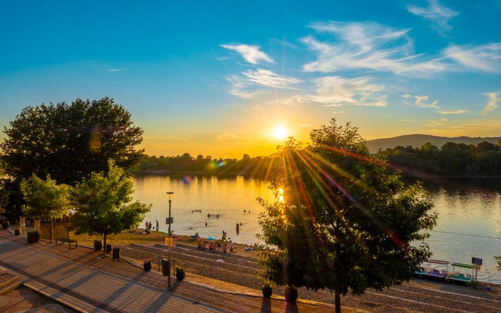 a view of a lake with the sun setting at Darja apartmani sa pogledom na jezero in Ostrovo