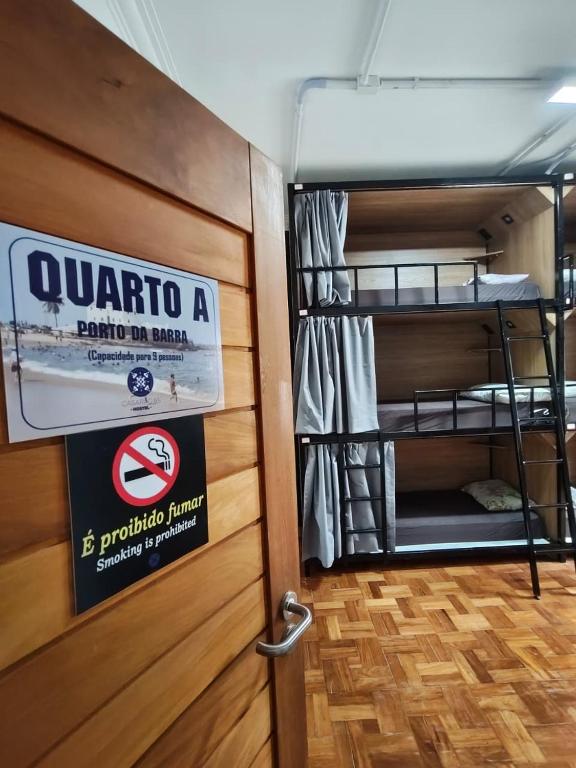 a room with bunk beds and a sign on a door at Hostel Casarão 65 in Salvador