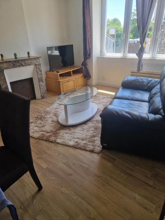 a living room with a couch and a coffee table at Appartement 2 Ch la Romagne in La Romagne