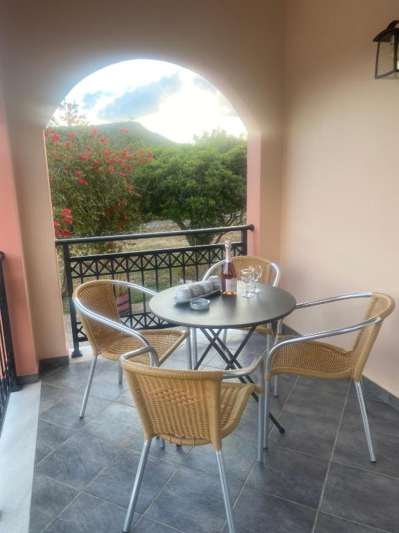 a table and chairs on a balcony with a window at Anemomilos in Samos