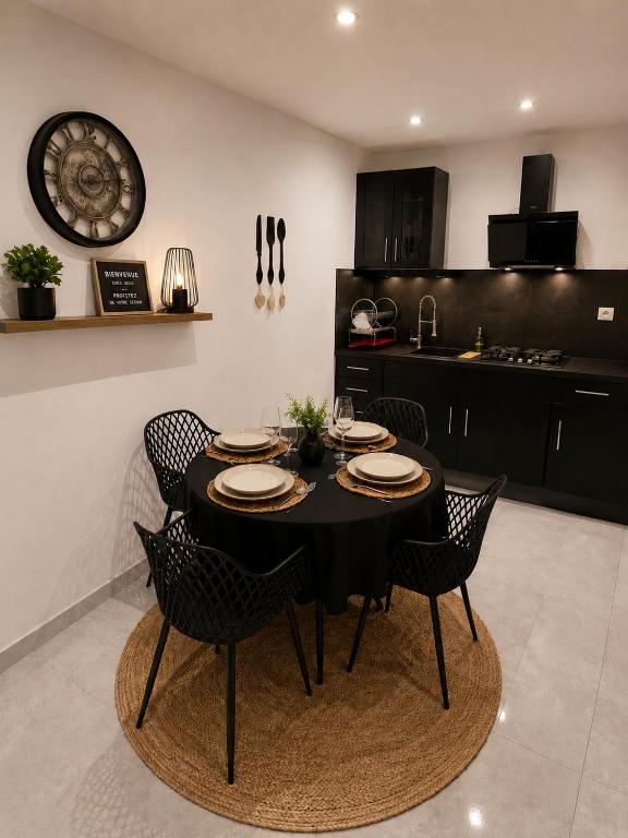 a dining room with a black table and chairs at Appartement T2 bis à morbier in Morbier
