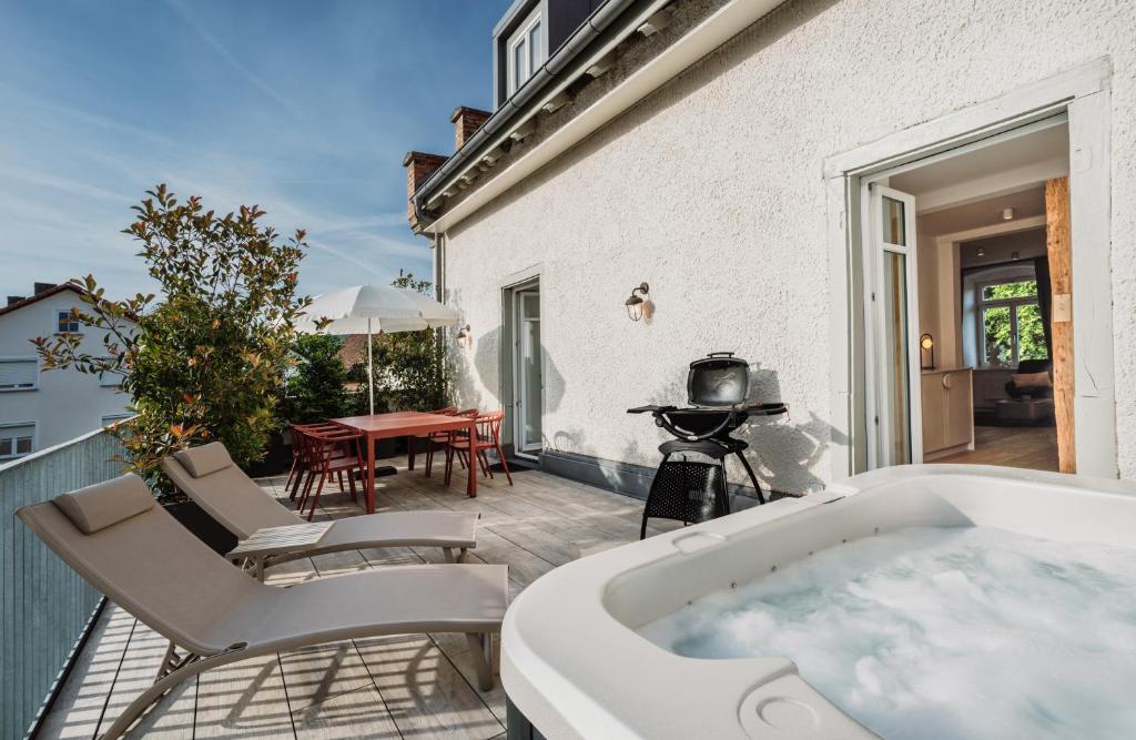 a bath tub on a patio with a table and chairs at Schloss am Bodensee I Private Sauna & Whirlpool in Stockach