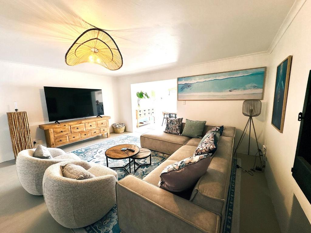 a living room with a couch and a flat screen tv at House Charisma in Britannia Bay