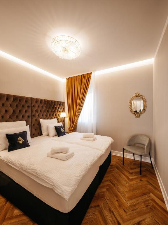 a bedroom with a large bed and a chair at B Residence - Boutique Apartments Ljubljana - Private Parking in Ljubljana