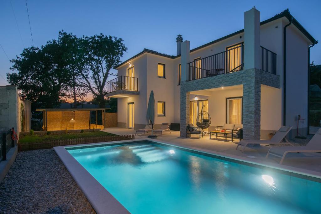 a house with a swimming pool in front of it at Villa Ginger Modern Villa with Private Pool in Omiš