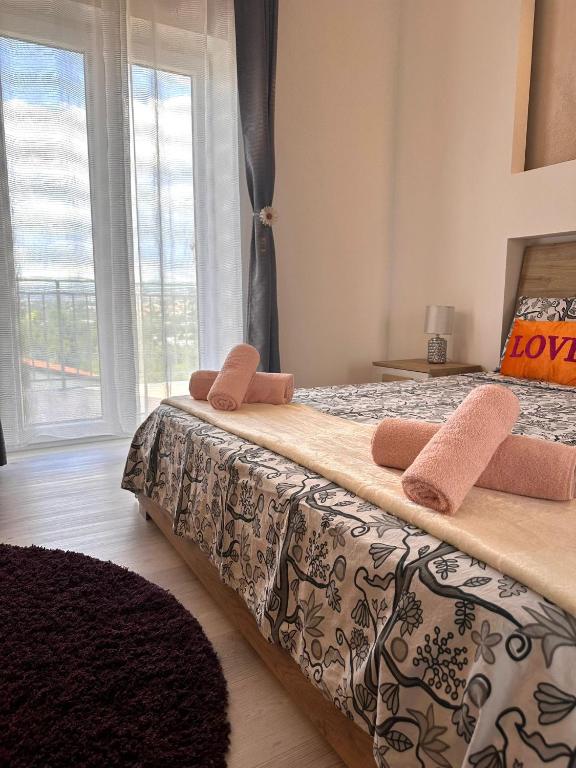 a bedroom with a bed with two pillows and a window at Deluxe apartment 2 rooms , near Koper and Trieste in Plavje