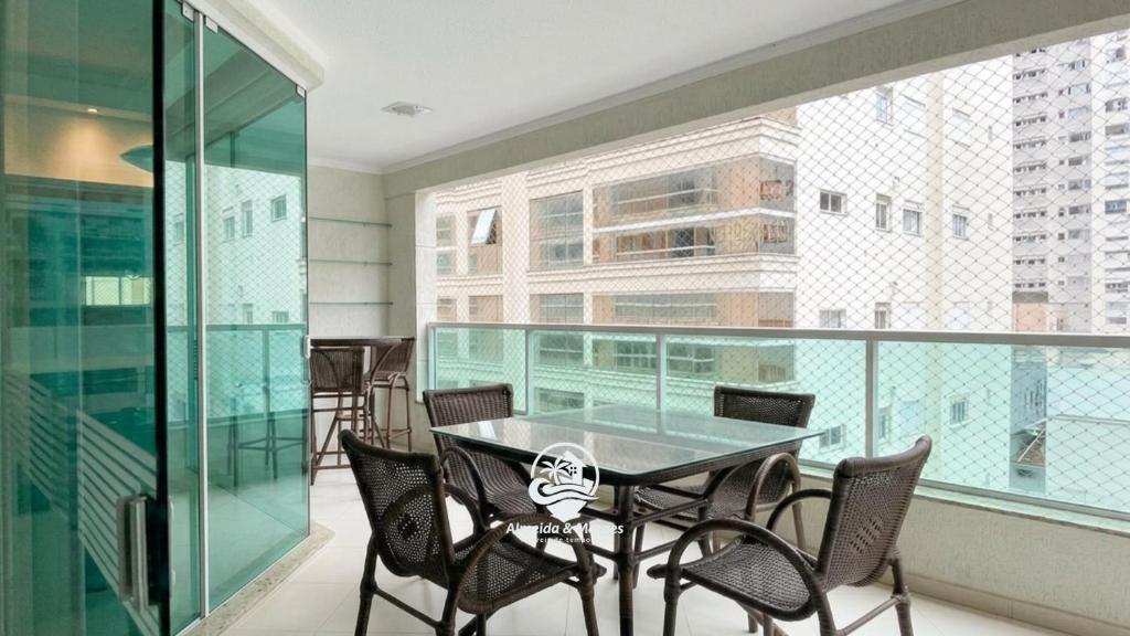 a room with a table and chairs on a balcony at Apartamento Almeida e Moraes 3 Suítes com Hidro in Itapema
