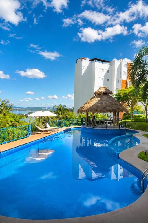 a pool at a resort with a building in the background at Hermoso departamento en Tequesquitengo alberca jacuzzi y acceso al lago in Tequesquitengo