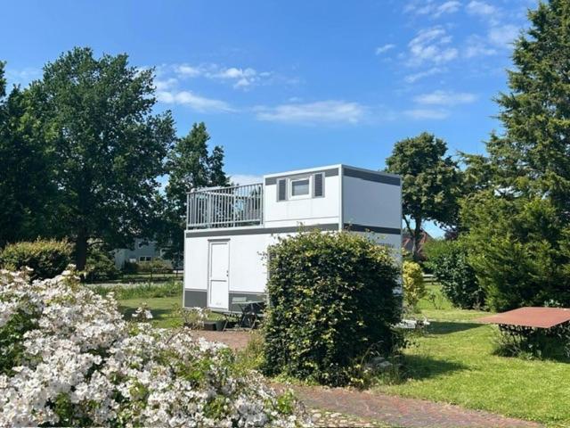 a white house with a balcony in a yard at Reetblick in Haseldorf