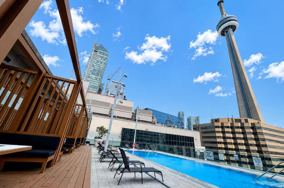a pool on the top of a building with chairs at Central City Suites with Free Parking in Toronto