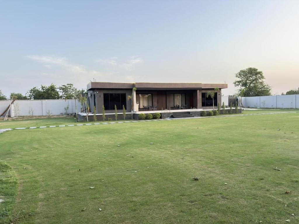a building with a large green field in front of it at SA Farms in Lahore