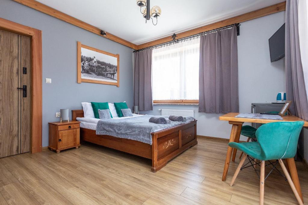 a bedroom with a bed and a desk with a computer at U Studniara in Murzasichle