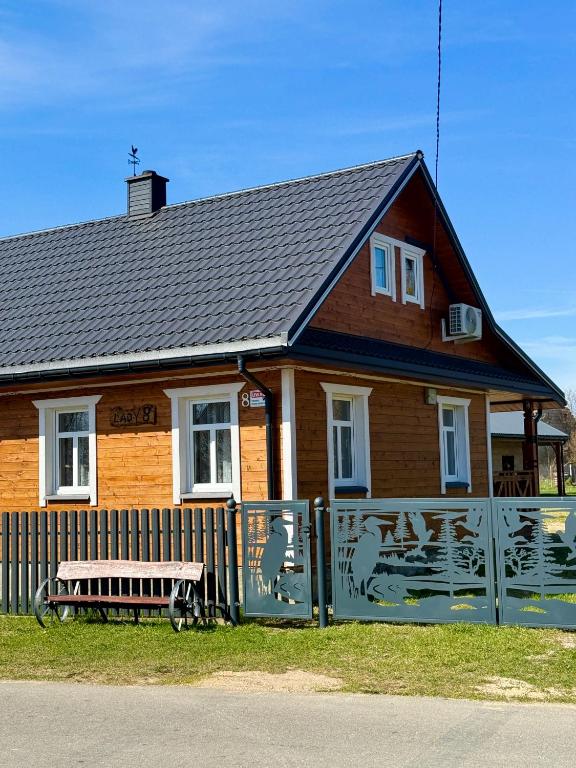 a house with a fence and a bench in front of it at Uroczysko Lady in Lady