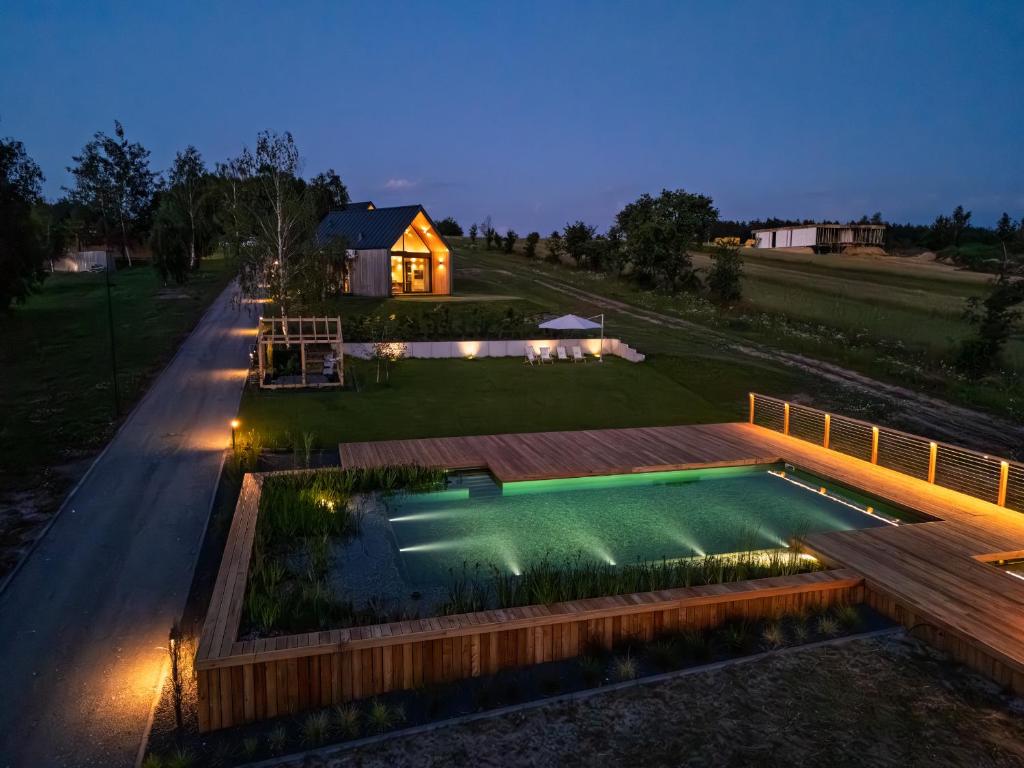 a backyard with a swimming pool and a house at Cztery Widoki Luksusowe Domki Góry Świętokrzyskie in Huta Szklana