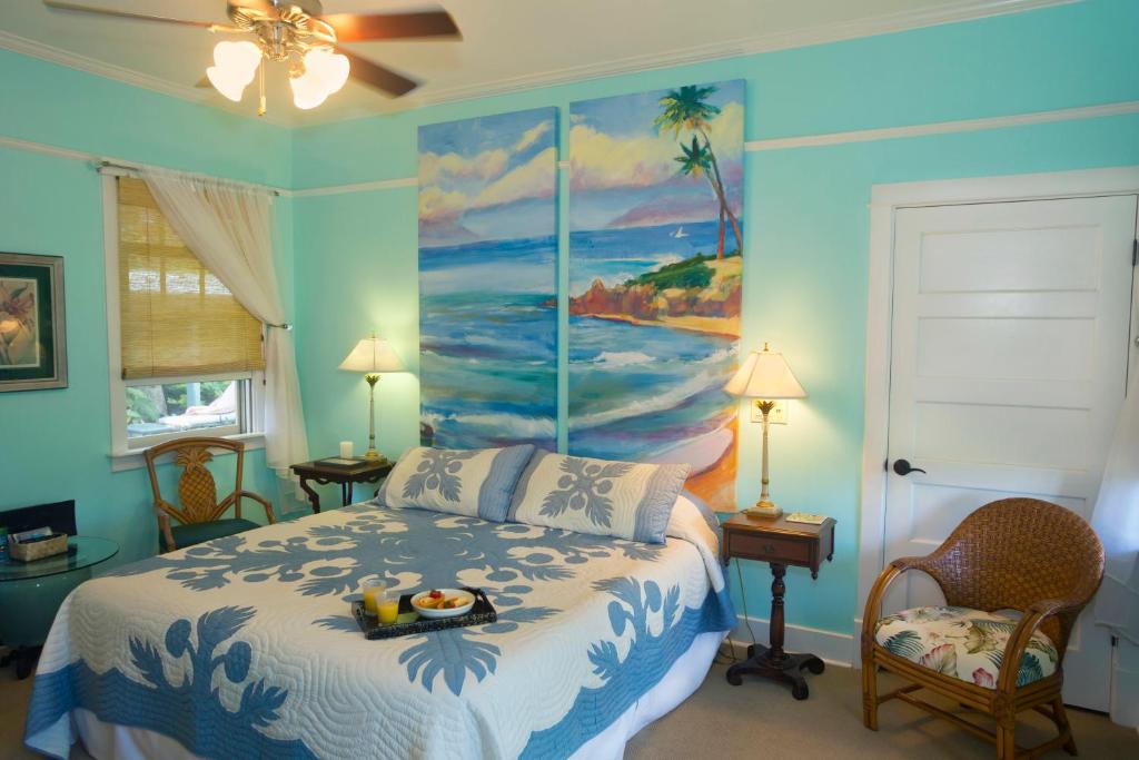 una camera da letto con un letto e un dipinto sul muro di Iao Valley Inn a Wailuku