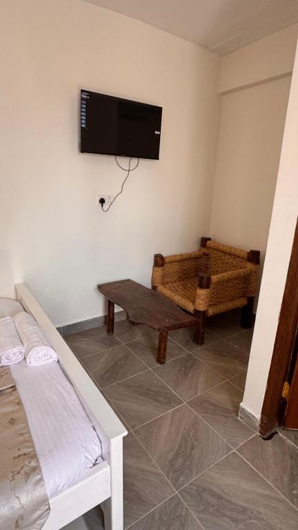 a room with a bed and a tv on the wall at Stlounge-kisaju in Stony Athi