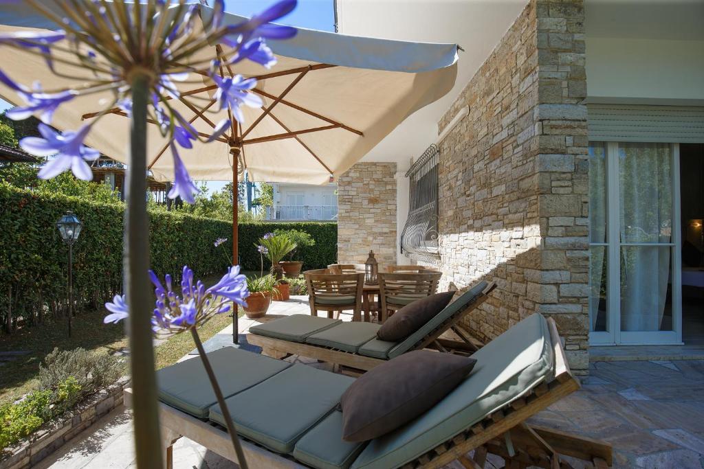 a patio with an umbrella and chairs and a table at B&B Ortensia in Forte dei Marmi