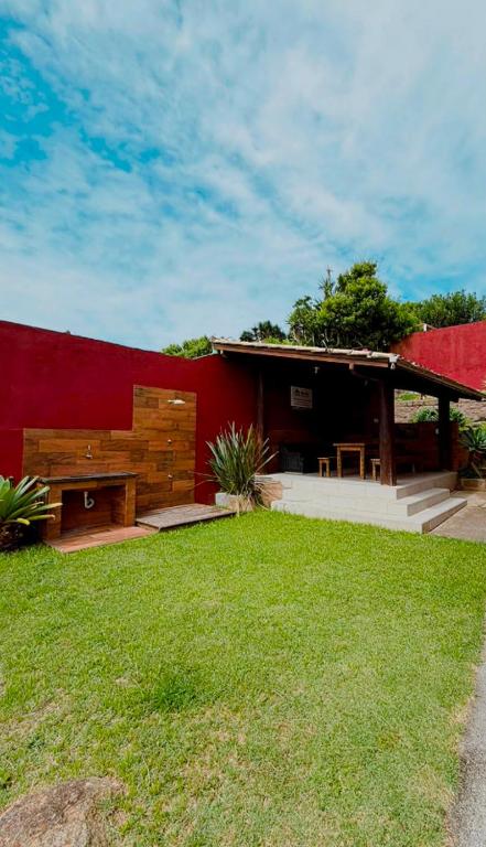 a house with a red wall and a grass yard at Casas 1 Terrace in Laguna
