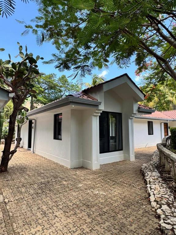 a small white house with a brick driveway at Private 2 Bedroom Home with Pool Near El Coco Beach in Coco