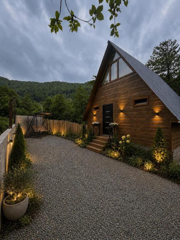 a wooden house with lights on the side of it at Makhuntseti Inn in Makhunts'et'i