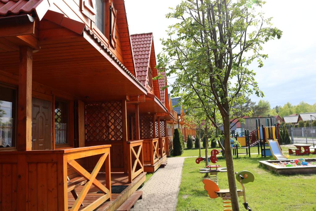 a house with a yard with a playground at Mandala Domki in Bobolin