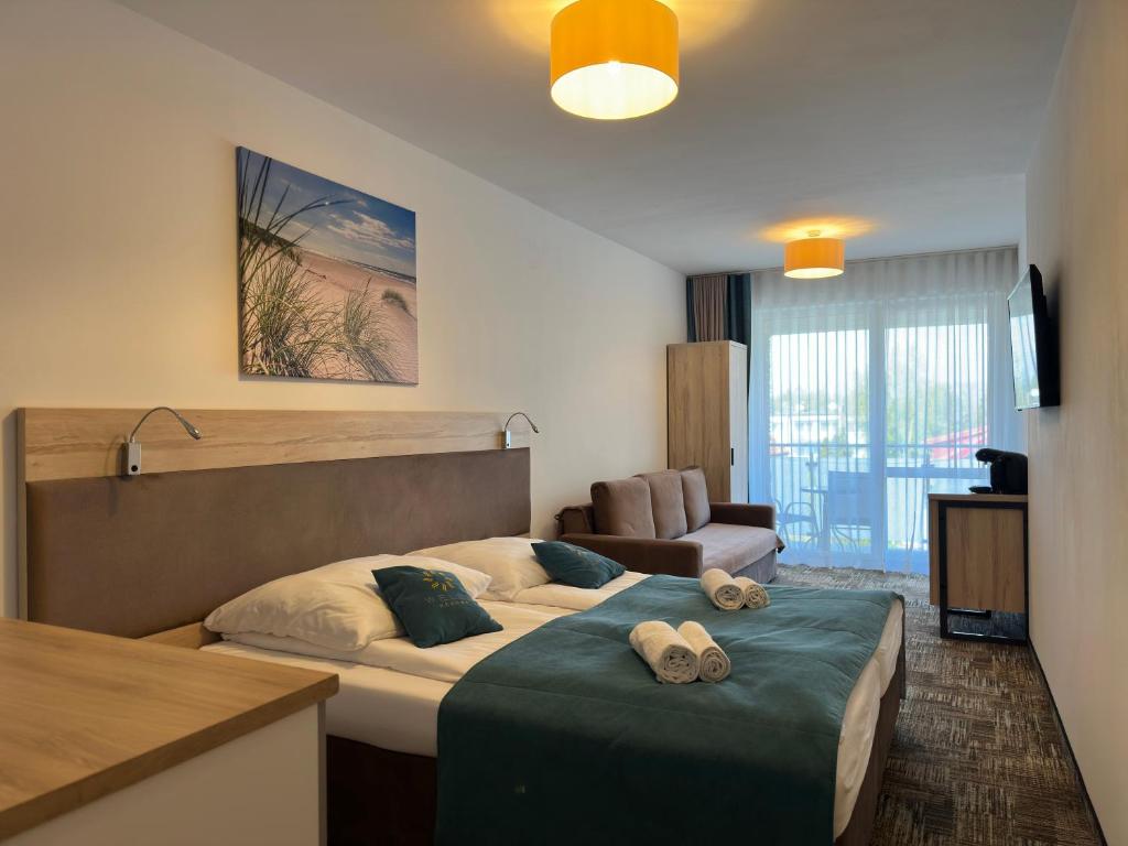a hotel room with a bed and a couch at Apartament Suzi in Grzybowo