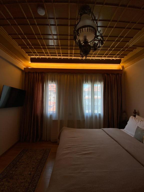 a bedroom with a large bed and a chandelier at MetsoVillas στο κέντρο του Μετσόβου in Metsovo