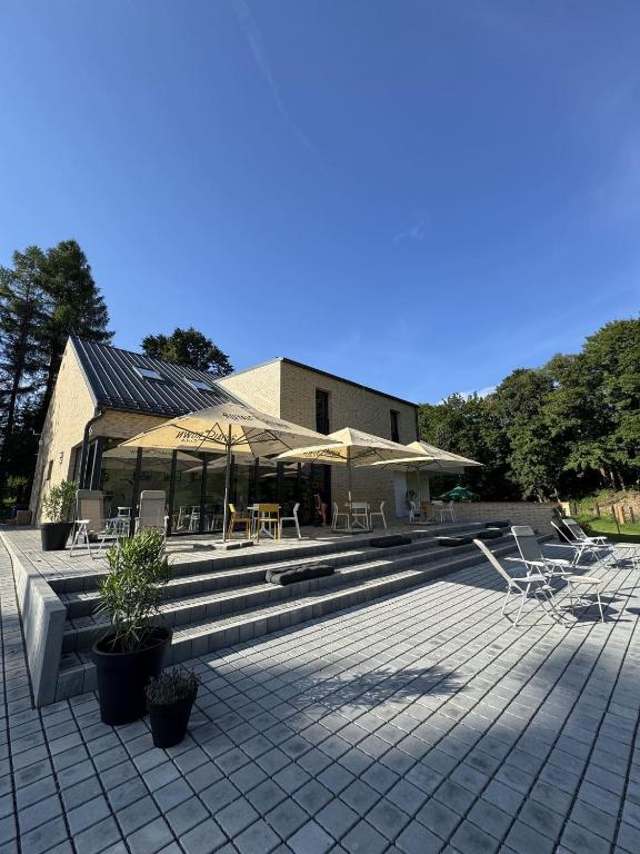a patio with chairs and tables and a building at Penzión ZAYDA in Výrava