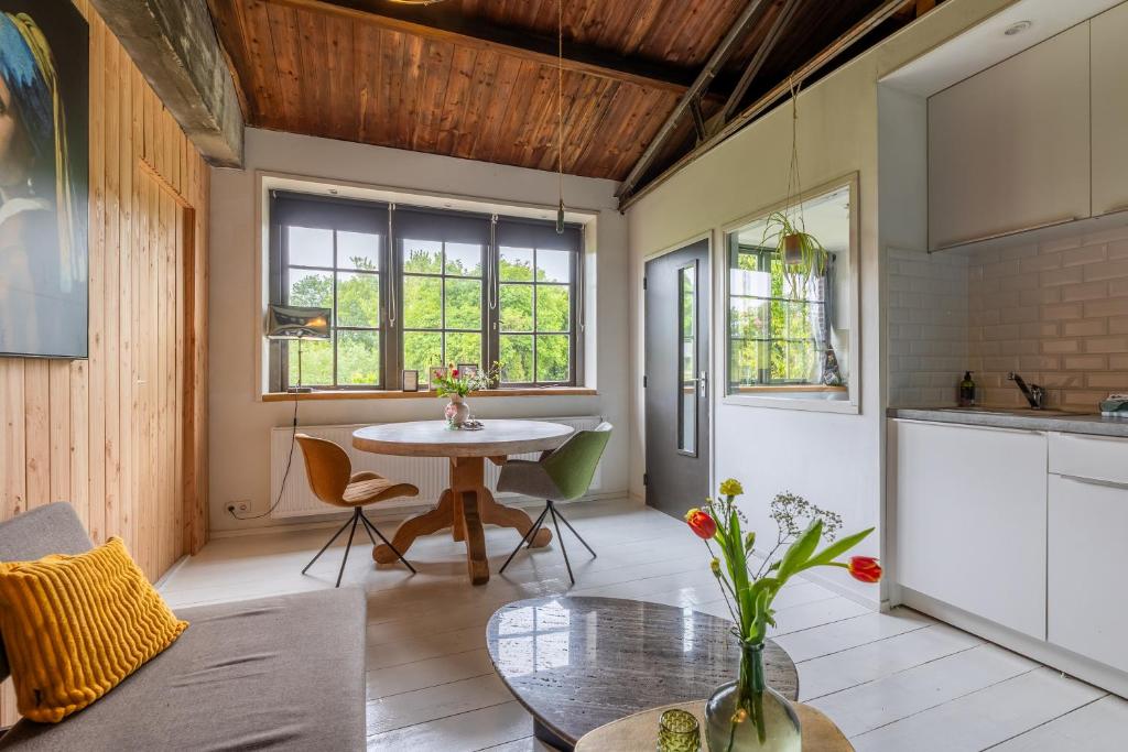 a living room with a table and a kitchen at Appartement de Tuinkamer in Kampen