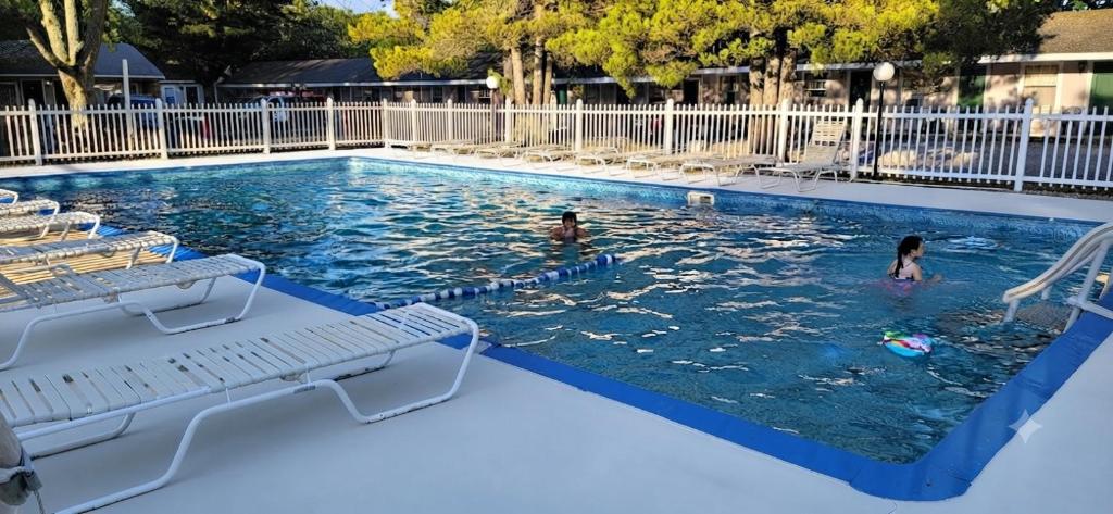 two people swimming in a swimming pool at The Tallwood Motel in Wells